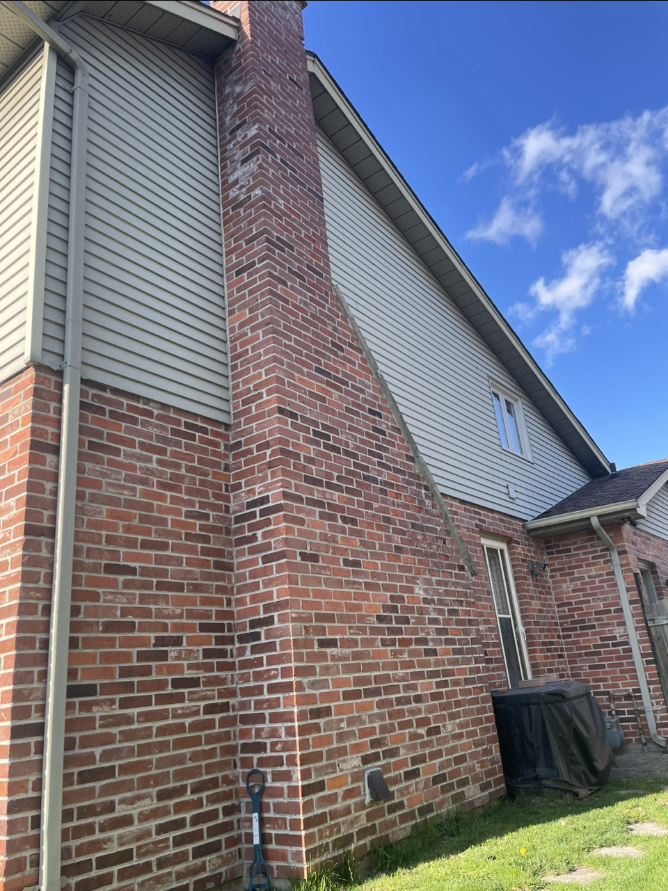 Rebuilt chimney integrated with the white brick exterior after restoration and masonry painting in London Ontario